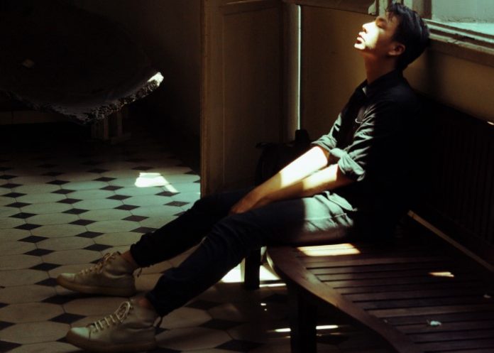 man-in-black-top-sitting-on-bench-beside-of-door-1532775